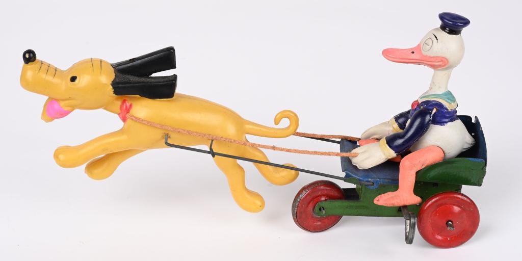 JAPAN DISNEY DONALD DUCK & PLUTO CELLULOID WINDUP: Pre war Japan long-billed Donald celluloid figure being pulled by celluloid Pluto. Tin cart and wheels, worked when tested. Celluloid is very nice with bright colors. Pluto has a complete tax stamp on
