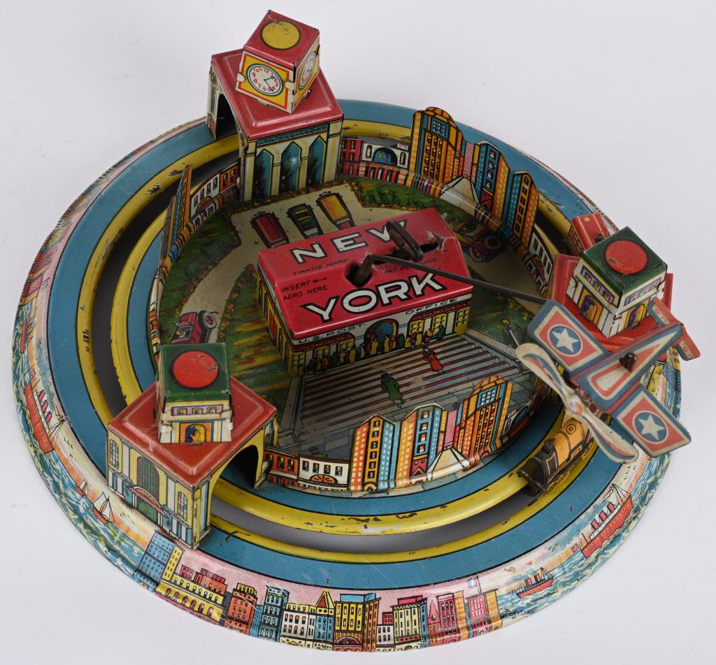 MARX TIN WINDUP NEW YORK GO ROUND: Wonderful Marx tin windup New York Go Round. All original and complete with the Airplane. Great colors and graphics. Windup works. A hard to find Marx toy! 9 1/2" Excellent