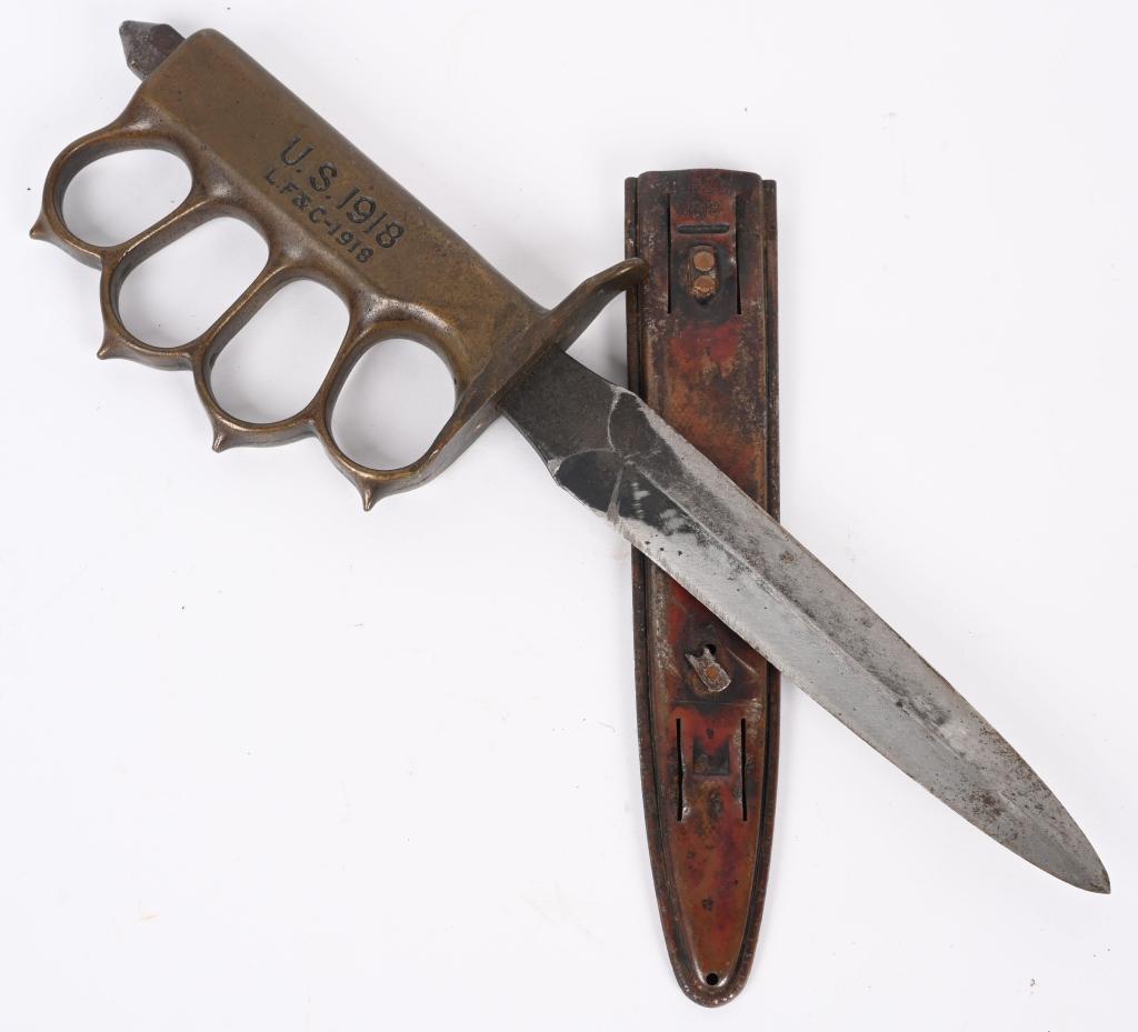 WWI US M1918 TRENCH KNIFE LF&C W/ SCABBARD WWII: Model 1918 "Knuckle Duster" Trench knife with solid brass handle made by Landers, Frary, and Clark and so marked "L. F. & C." on the handle and on the scabbard. Features spiked knuckle guards, and "Sk