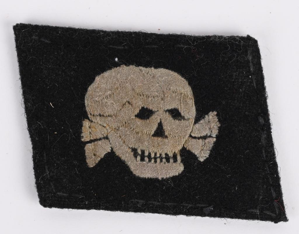 WWII NAZI GERMAN WAFFEN SS TOTENKOPF COLLAR TAB: Right hand side, unit designation, collar tab features a machine embroidered, horizontally positioned, skull superimposed over crossed bones in silvery/grey cotton threads on a black wool base. The sk