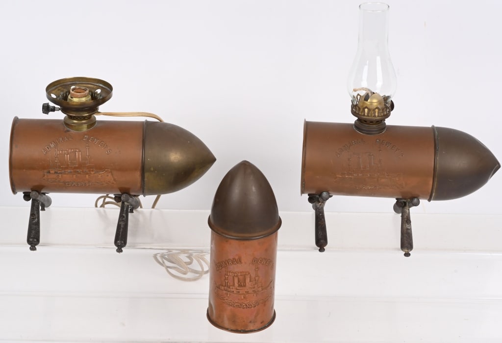 SPAN AM ADMIRAL DEWEY'S ARTILLEY SHELL LAMP & CASE: Admiral Dewey Artillery Shell Lamps and lidded shell lot to include 1) Lidded Artillery Shell measuring 7 3/4 inches tall that has an image of the USS Maine and Admiral Dewey's. Shell has minor dents 