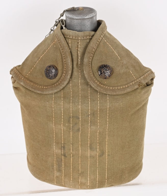 EAGLE SNAP CANTEEN COVER & SEAMLESS CANTEEN M1910: Rimless Eagle Snap closure button, green canvas cover. The canteen is a very early pattern with a seamless body and early style cap. It is unmarked as is proper for this style. A scarce early issue ca