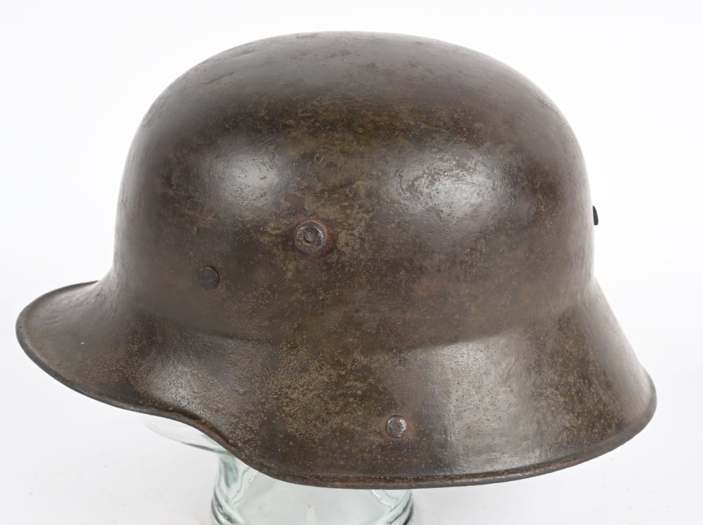WW1 IMPERIAL GERMAN M17 HELMET W/ LINER CHINSTRAP: The stamped, sheet steel construction helmet retains a good portion of its original field-gray paint. The helmet has all three flat headed, liner retaining rivets, both dome headed chinstrap retaining