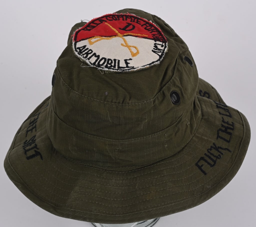 VIETNAM AIRMOBILE PATCHED BOONIE HAT: Vietnam Boonie hat that is embroidered on the brim FUCK THE LIFERS to one side and IN THE SHIT on the other. To the top center a theater made Air Mobile Troop D patch with the caption KILL A COMMIE FO