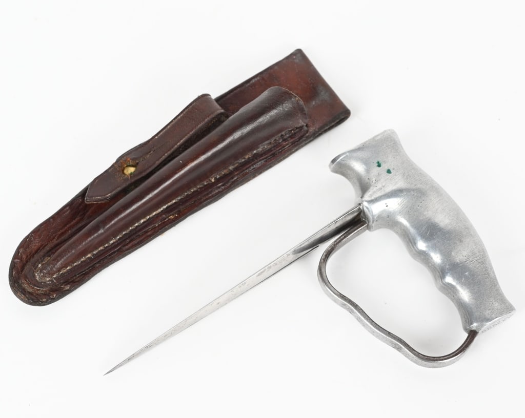 WWI BRITISH ROBBINS OF DUDLEY PUSH DAGGER SCABBARD: This is a very nice example of a rare Robbins of Dudley push knife with a period leather scabbard. This unusual aluminum handled, knuckle push dagger style knife was made for stabbing from behind, and