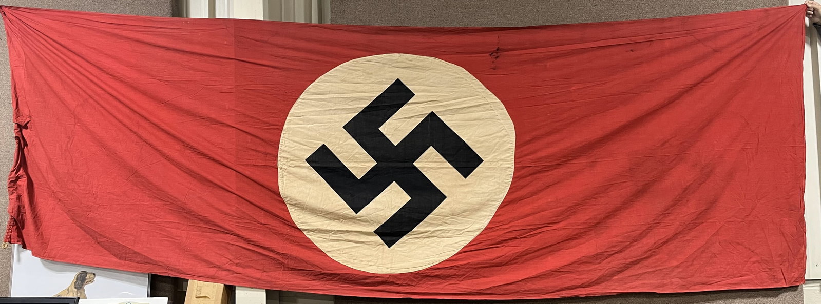 WWII NAZI GERMAN NSDAP WALL BANNER OR FLAG WW2: Multi-piece cotton construction banner approximately 57 X 176 inches. To both its red fields are sewn white disks, with printed mobile swastikas in black. Minor holes and fraying. Probably one of the 