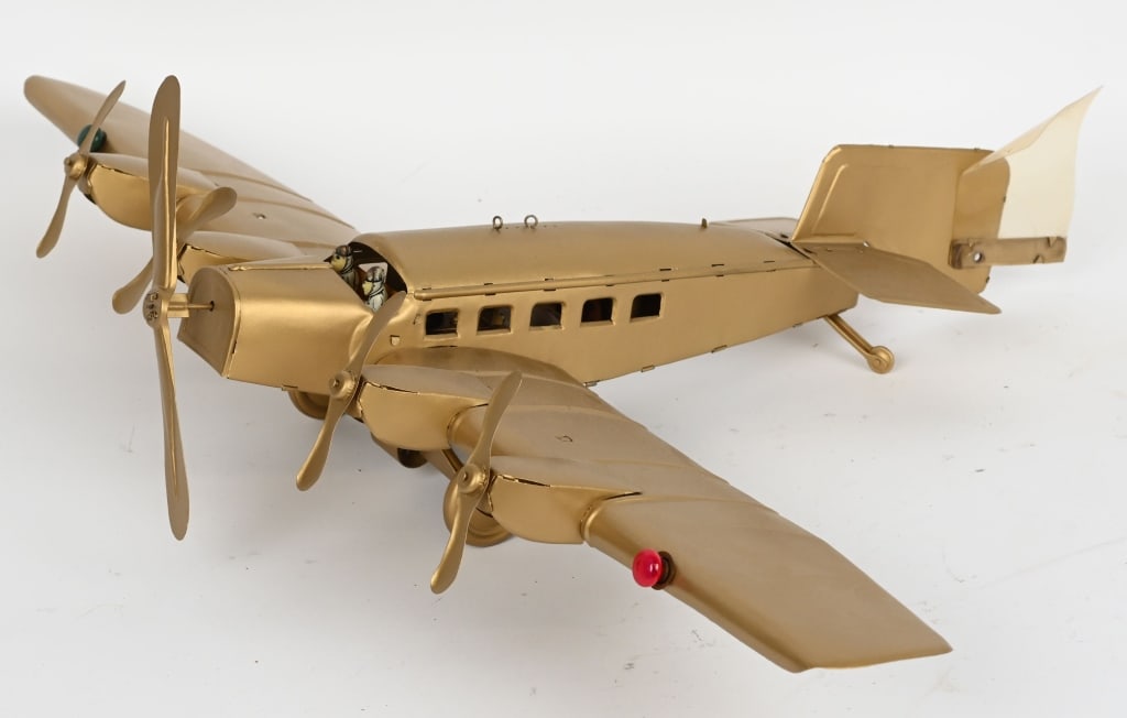 GUNTHERMANN WINDUP GOLDEN ARROW AIRPLANE: Gunthermann tin windup Golden Arrow Airplane. All original and in wonderful condition. Has electric lights. Still has 2 Pilots. Windup works. A scare and desirable Airplane. 28" Wingspan. Excellent