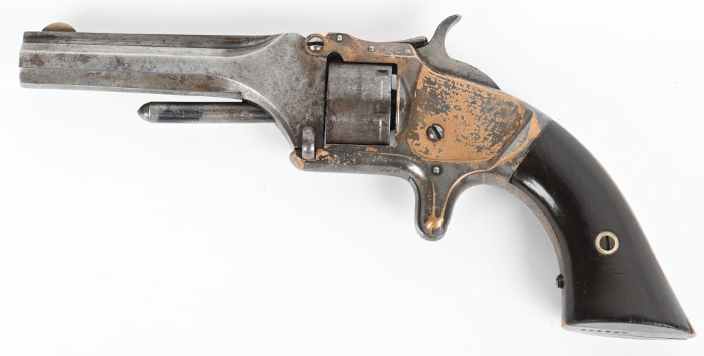 SMITH & WESSON MODEL 1 2ND ISSUE: SERIAL 123377. BARREL 3". CALIBER 22RF. 1860-1868. Tip up, plated brass frame, octagon barrel with rib, spur trigger, rosewood grips. Condition. Flashes of plating remains. blue brown patina on cylind