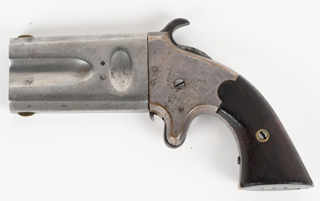 SCARCE AMERICAN ARMS OVER UNDER DERINGER: Made in Boston 1866-1871. This is in 41 rimfire with a 2 5/8" rotating barrel, silver plated frame, spur trigger with walnut grips. This is serial number 428 of approximately 500 made in several combi