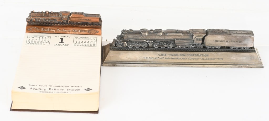 VINTAGE RAILROAD CALENDAR & DESK ORNAMENT: Includes a 8" 1964 Desk calendar with cast Reading Railway System header. Also included is 10 1/2" Lima Hamilton Corp Chesapeake & Ohio cast metal desk ornament. Both excellent