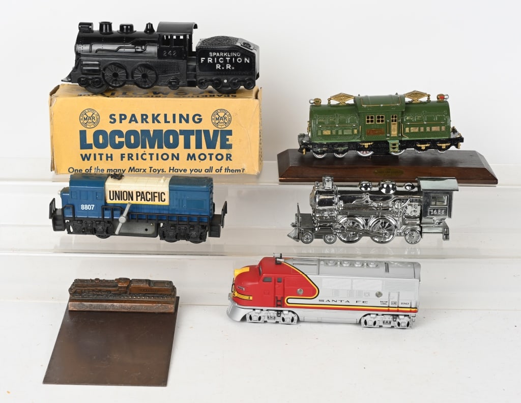 MARX and MISC. TRAIN ITEMS: Includes boxed Marx plastic friction Locomotive, Hong Kong windup Union Pacific engine, China battery op Santa Fe engine, Avon bottle, Lionel desk train engine, and Reading Railway metal calendar head