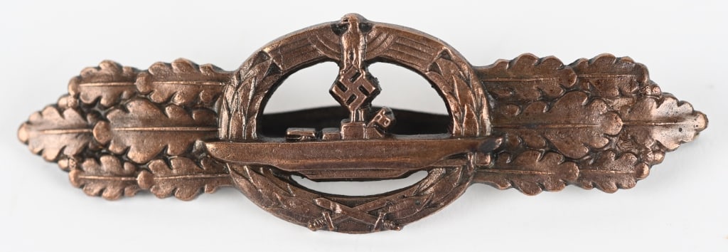 WWII NAZI GERMAN U-BOAT COMBAT CLASP IN BRONZE WW2: Die cast, zinc alloy construction, later version clasp with a bronze washed finish is in the form of central, horizontally oval, embossed, laurel leaf wreath, with a stylized national eagle with uniqu