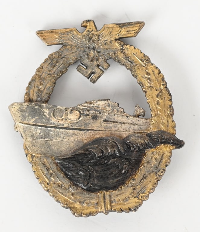 WWII KRIEGSMARINE SCHNELLBOOT E-BOAT BADGE WW2: Die struck second pattern S-boat badge. The badge is in the form of a vertically oval oak-leaf wreath with a small national eagle with out-stretched wings superimposed to the top center encompassing a