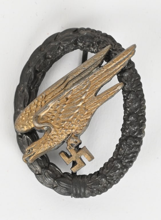 WWII NAZI GERMAN LUFTWAFFE PARATROOPER'S BADGE WW2: Two piece, die struck zinc award features a stylized, "diving", eagle clutching a swastika in its talons, encompassed by a vertically oval wreath. The wreath features embossed laurel leaves to the rig