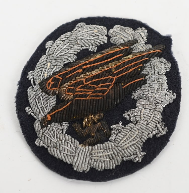 WWII NAZI GERMAN PARATROOPER BADGE IN BULLION WW2: Beautiful hand embroidered silver and gold threads feature a stylized "diving" eagle clutching a swastika in its talons, encompassed by a vertically oval wreath. The wreath features embossed laurel le