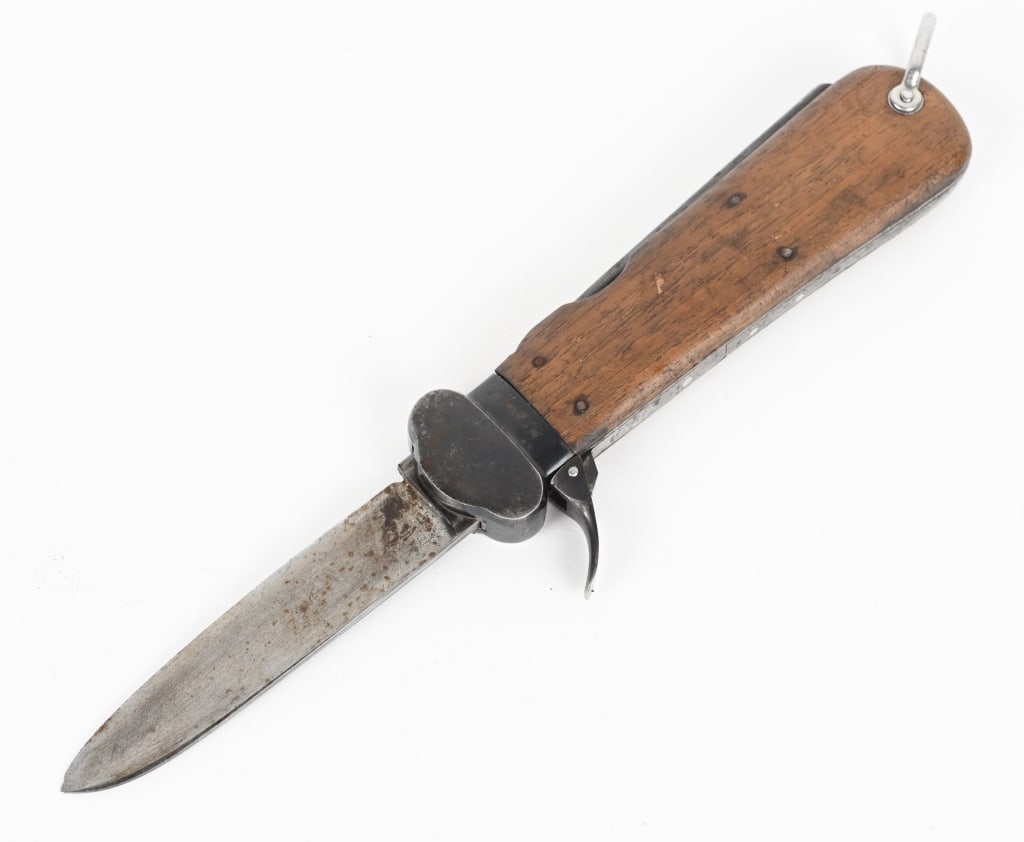 WWII NAZI GERMAN FALLSCHIRMJÄGER GRAVITY KNIFE WW2: A Luftwaffe paratrooper knife using a sliding steel blade inside a metal grip fitted with walnut, the grain running through vertically, grip plates. The blade is a relatively blunt spear-point with a 