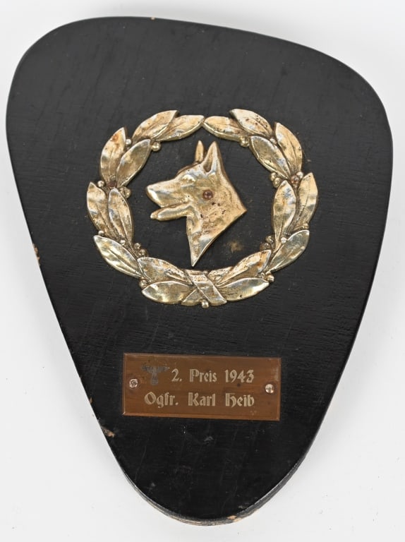 WWII NAZI GERMAN DOG HANDLING PLAQUE NAMED WW2: WWII Nazi German Dog Handling Wooden Plague measuring 5 1/2 X 7 1/4 with a metal wreath with a profile of a German Shepard. Beneath the wreath " 2. Preis 1943 Ogfr. Karl Heib" Excellent.