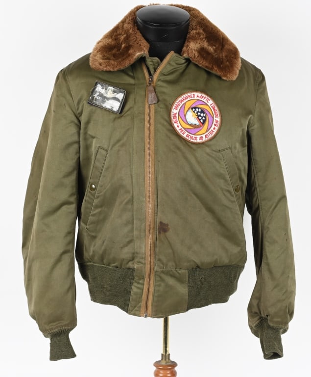 WWII US ARMY AIR CORPS B-15 NAMED FLIGHT JACKET: Olive color cotton fabric type B-15A jacket with fur collar and fur-lined, front "CONMAR" zip fastener with leather pull tab. Two slant side pockets with press button closure, left sleeve pencil patch