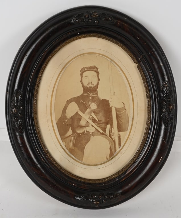 CIVIL WAR WELL ARMED ALBUMEN OF INFANTRY MAN: Framed Civil War albumen of a very well armed Infantryman. The frame measures 11 1/2 X 13 3/4 inches with the soldier wearing a 9 button enlisted Frock Coat with a Forage Cap as well as a cartri