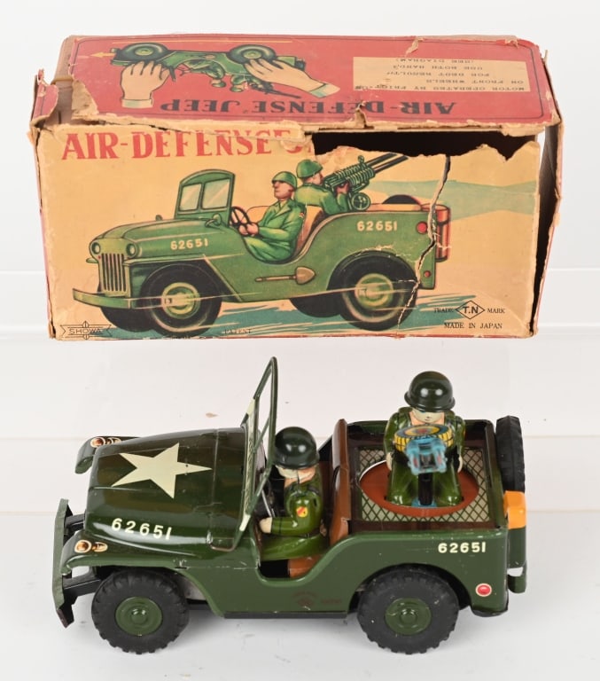JAPAN TIN FRICTION AIR-DEFENSE JEEP w/ BOX: The toy is complete and original and the friction motor works. The original box is fair with tears and tape. 7 3/4" Excellent