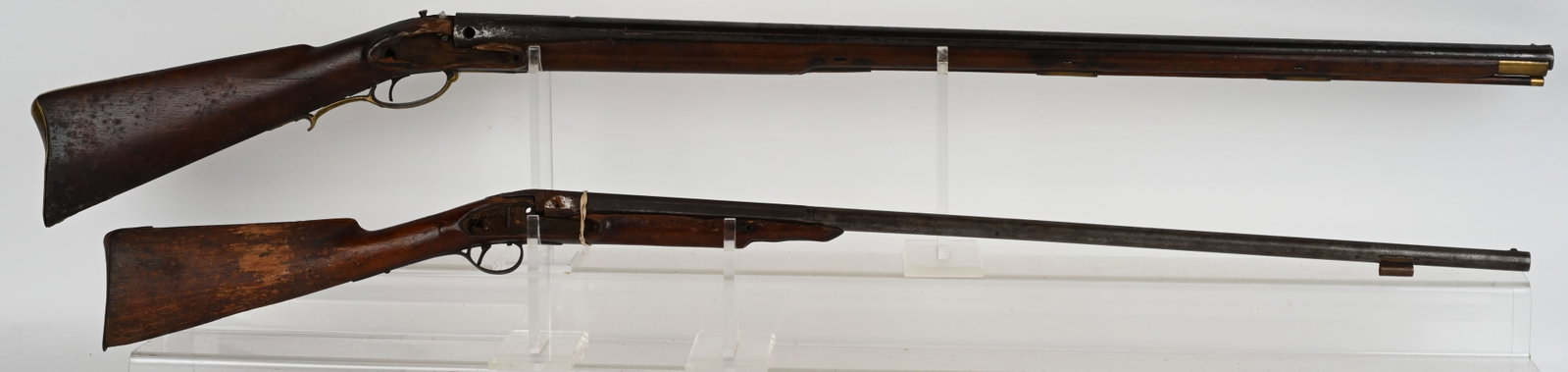 LOT (2) ANTIQUE GUNS GUNSMITH SPECIAL: A. Parts only. broken stock, no lock, B. .65 CALIBER, No lock or hammer, brass furniture, stock is good, basically another parts gun. ANTIQUE AS IS