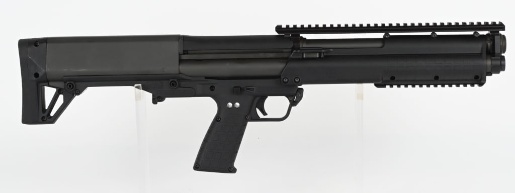 KEL-TEC KSG 12 GAUGE BULL PUP SHOTGUN: SERIAL NUMBER: XNV90. BARREL: 18-1/2". CALIBER: 12 GAUGE. MANUFACTURED: 2010S. Gen 1 gun, with a flat top rail (no iron sights present). Phosphate finished metal parts and black polymer stock chassis.