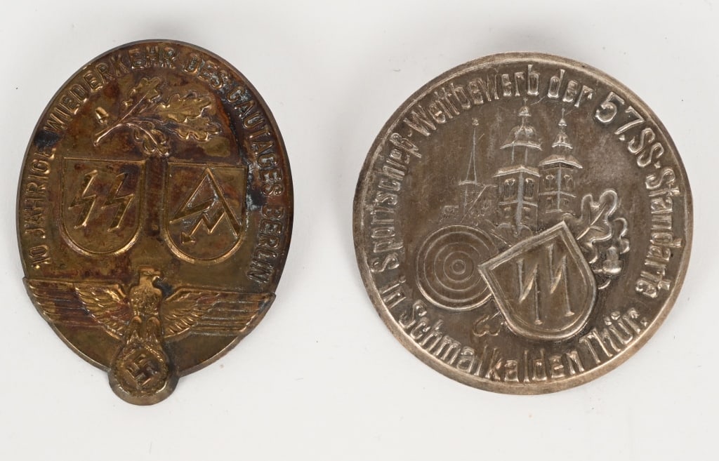 WWII NAZI GER WAFFEN SS TINNIE SHOOTING DAY BADGE: Lot of Two WWII Waffen SS Tinnies to include 1)10 jahrige wiederkehr des gautages berlin SS/SA Tinnie. SS / SA Tinnie commemorating the 10 year anniversary of Gau Day Berlin. Hollow pin back, unmarked