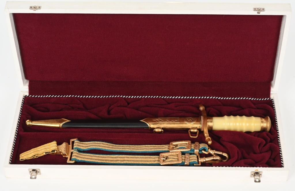 EAST GERMAN ADMIRAL’S DAGGER IN PRESENTATION CASE: No maker mark, but the ricasso is stamped with the number 05447. Gilded hilt fittings show no wear to the pommel cap with state insignia of a hammer and compass. Off-white grip and curved crossguard w