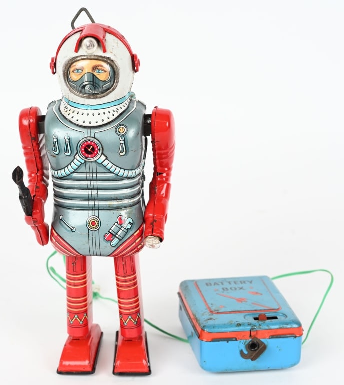 TN BATTERY OP SPACE MAN ROBOT: Nomura battery operated Space Man. Made in Japan. All original and complete. Has headlamp, flashlight, and space gun. Comes with correct remote battery box which has crazing. Robot worked when tested.