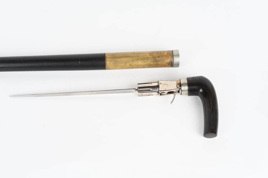 19TH CENTURY FRENCH PEPPERBOX CANE GUN: SERIAL NUMBER NSN BARREL 1 3/8", CALIBER 5MM, Scarce cane gun with 6 shot revolver pepperbox barrels and 8" fluted spike blade. It is marked "Paris A Brevette". The grip is horn. The wood shaft is 33"