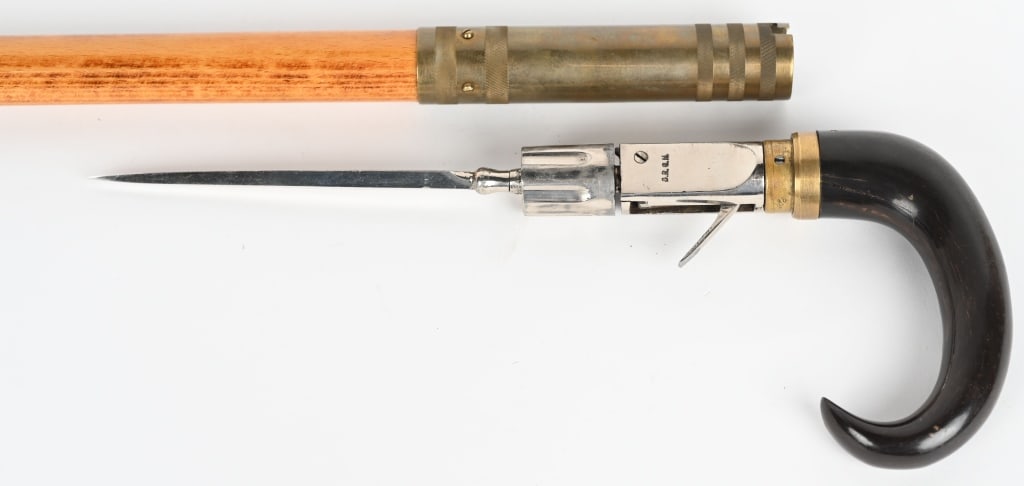 19TH CENTURY GERMAN PEPPERBOX CANE GUN: SERIAL NUMBER 40 BARREL 1 1/4", CALIBER 5MM, Scarce cane gun with 6 shot revolver pepperbox barrels and 5" spike blade. It is marked "D.R.G.M." on left side of frame. The brass collar on the grip is m