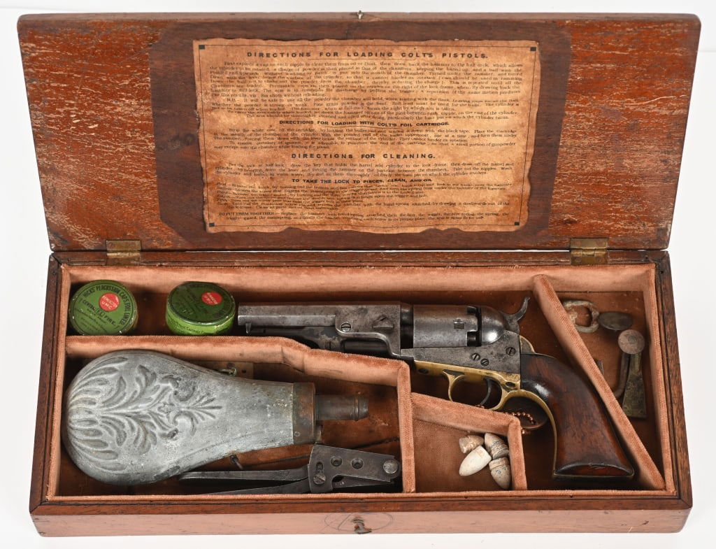 CASED COLT 1849 POCKET MODEL REVOLVER: SERIAL NUMBER 121689 BARREL 4" CALIBER .31 PERCUSSION MANUFACTURED 1856. Two line New York address with Stagecoach Ormsby cylinder scene. Cased with pewter flask, .36 Colt marked bullet mold and 2 sea