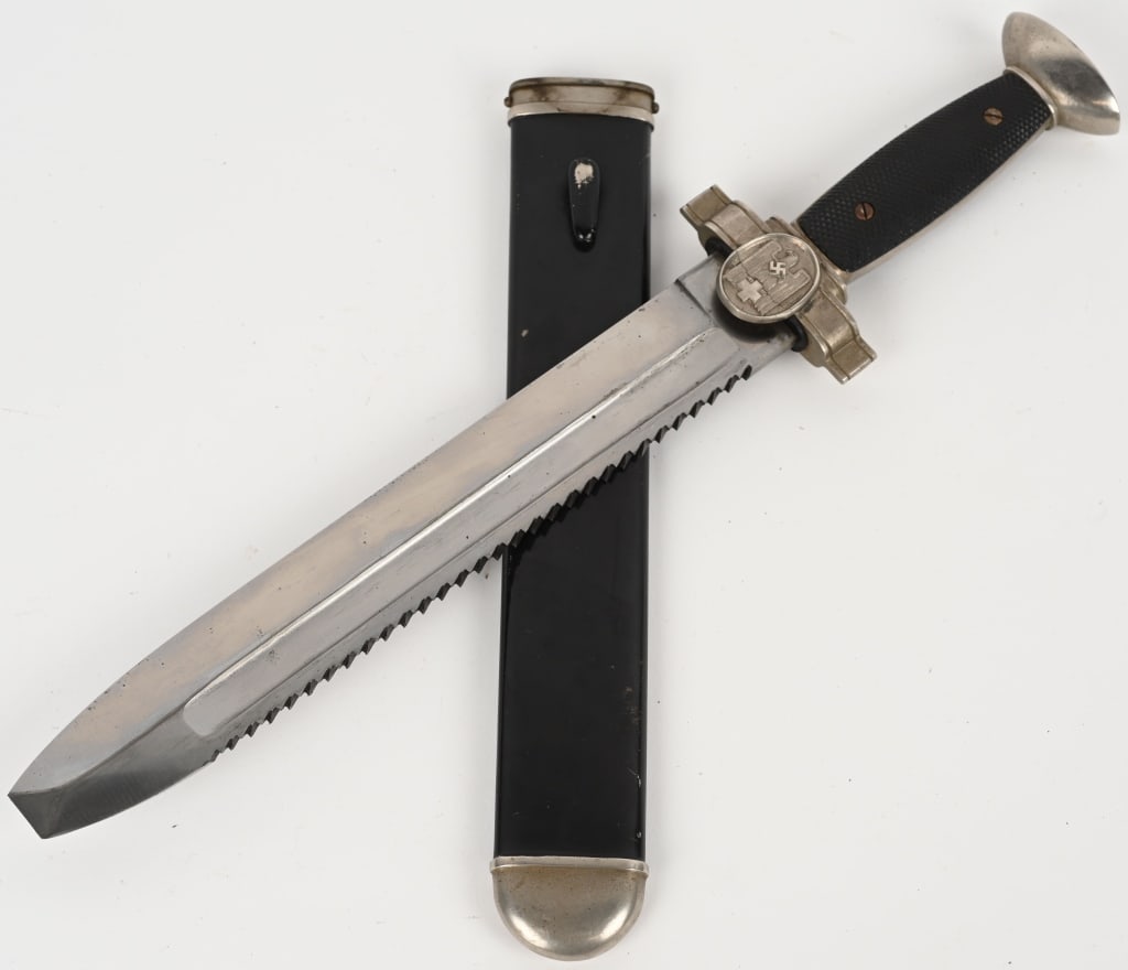 WWII NAZI GERMAN RED CROSS HEWER DAGGER WW2: The hewer features a roughly, 10 1/2", (26.6 cm), long, broad, squared, blunt tipped, nickel/silver plated, drop forged, steel construction blade with deep, wide, fullers, a staggered, saw-toothed, ed