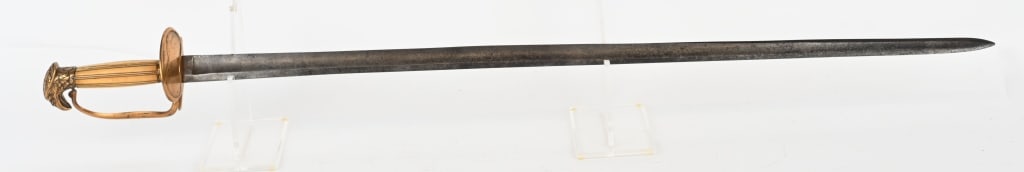 EARLY 19TH CENTURY EAGLE HEAD SWORD: The is 37 1/2" overall with a 32" single edge straight blade that is 1" wide at the ricasso. The blade has a stopped fuller on each side. There is an indiscerible name etched on the left side of the b