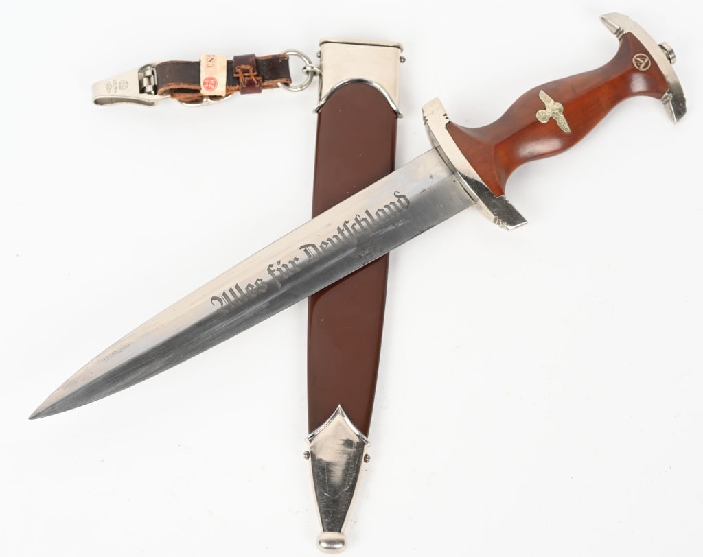 WWII NAZI GERMAN SA DAGGER BY GUSTAV C. SPITZER: SA dagger with a 22cm long double-edged drop-forged, and nickel-silver plated blade in its original scabbard. The dagger has a cast pommel and tang nut. Its contoured wooden grip has, inlaid to its ob