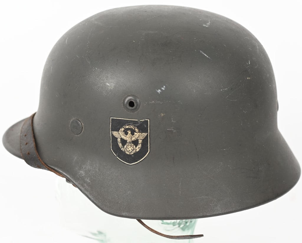 WWII NAZI GERMAN DD M40 POLICE HELMET Q64 WW2: The stamped, sheet steel construction helmet M40 retains about 99% of it’s original age and usage darkened, slightly rough textured, field-gray paint. The helmet has the fourth and final pattern