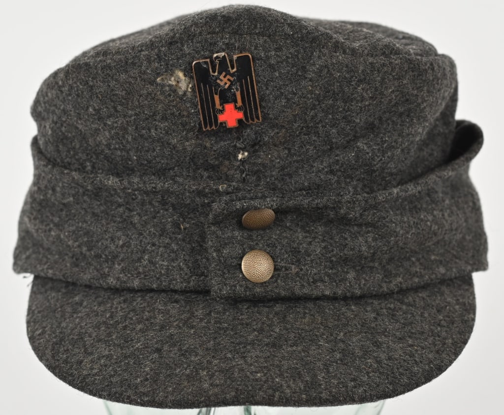 WWII NAZI GERMAN M43 RED CROSS DRK CAP W INSIGNIA: An Red cross M43 cap, constructed of dark gray wool twill. It is fully surrounded by decorative fold-down side panels in the style of a M43 field cap. Pinned onto the front of the paneling are two peb