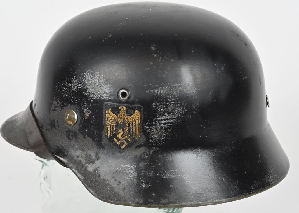 WWII NAZI GERMAN KRIEGSMARINE M40 SD HELMET WW2: The stamped, sheet steel construction helmet retains about 75% of its smooth, black paint with camo overtones. The left side of the helmet has a Wehrmacht eagle shield decal featuring a deep, golden y