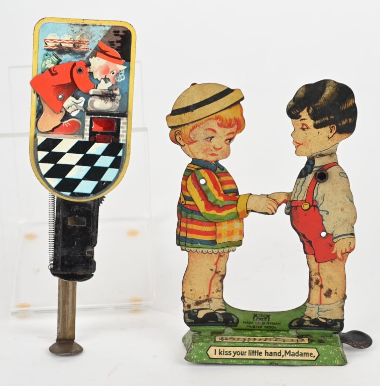 2- GERMAN TIN MECHANICAL TOYS: Lot includes. 1. 5" George Levy Boy and girl, nice colors with wear. 2. 6" Man cooking duck sparkler. Nice graphics and colors. Not working properly and does not spark. Very Good