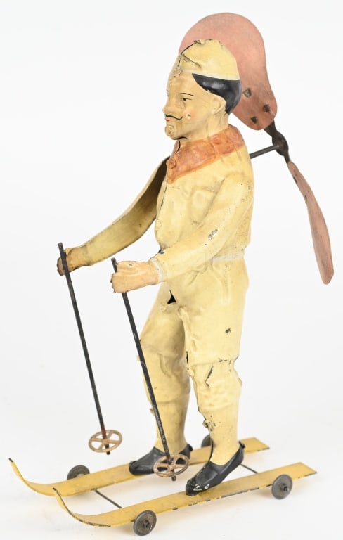 GERMAN MAN ON SKIS WITH PROPELLER: German hand painted tin windup Man on Skis with Propeller. Large and very detailed toy Windup works. Has some touchup,. 8 1/2" Excellent