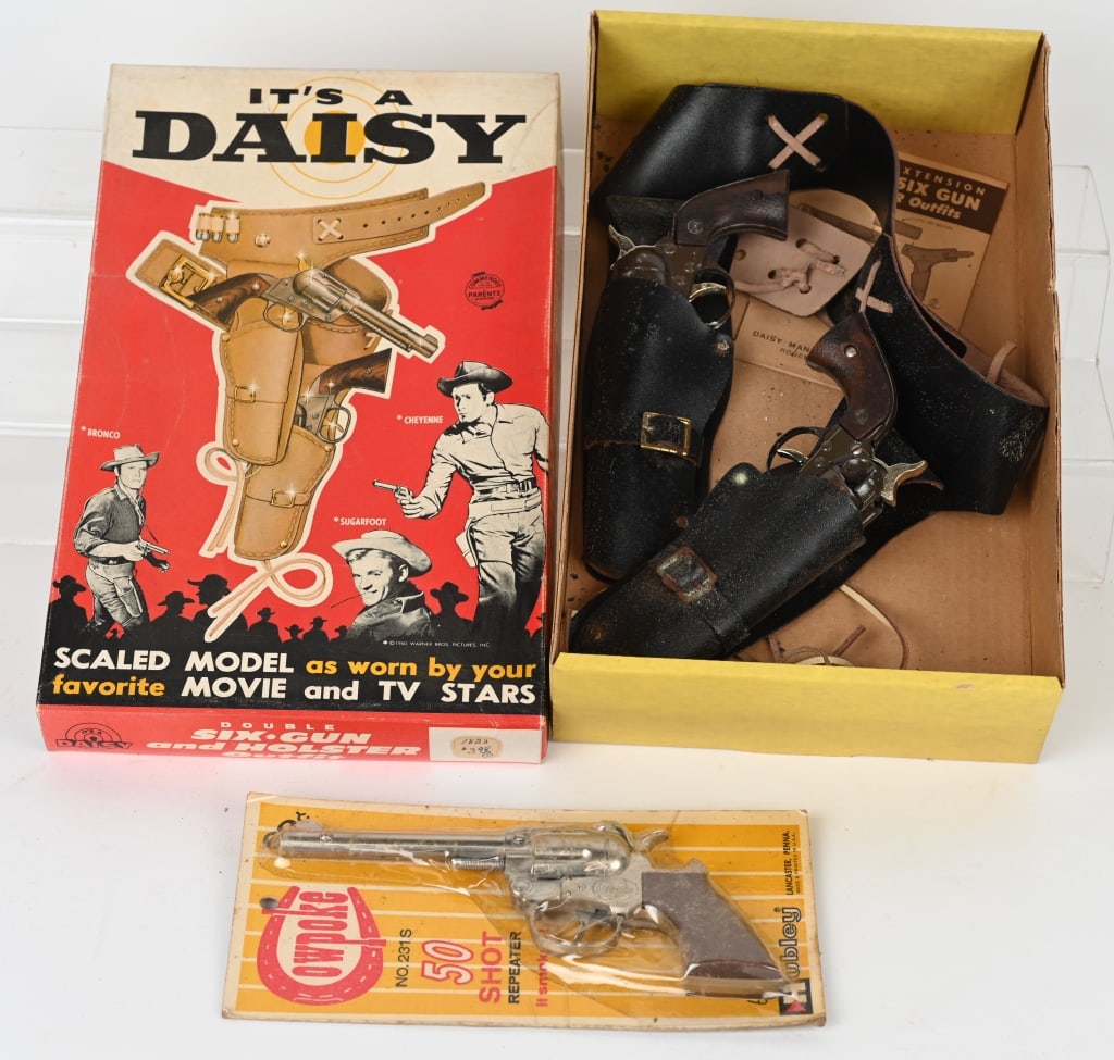 DAISY DOUBLE CAP GUN SET & HUBLEY COWPOKE BOXES: Lot includes 1. Daisy Double Six Gun set. Some wear and loading gate is off of one pistol,, Good 2. Hubley Cowpoke 50 shot cap gun sealed on card. Excellent