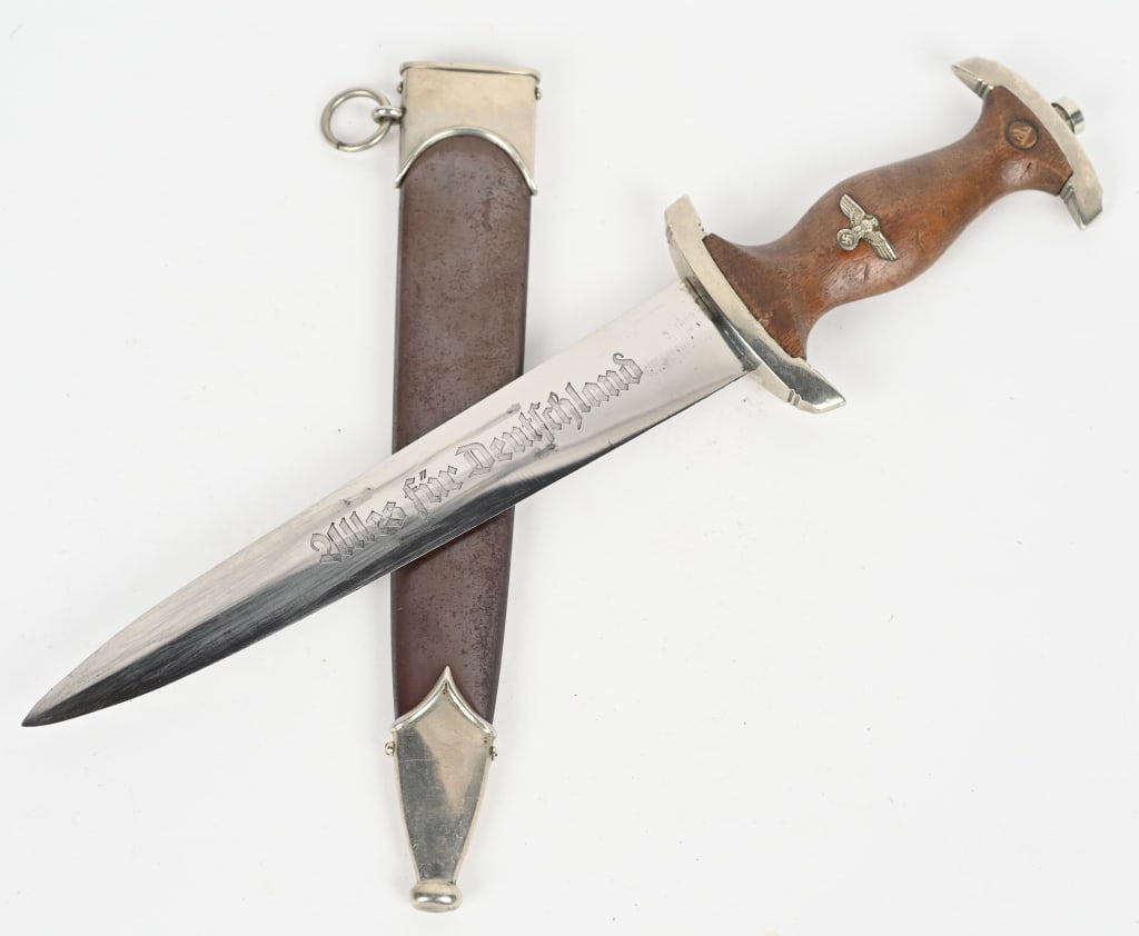 WWII NAZI GERMAN SA DAGGER BY J.P. SAUER & SOHN: Double edged, nickel/silver plated blade with a low central ridge. Blade is in overall excellent condition with original cross-graining still visible. Shows the normal scabbard runner marks and typica