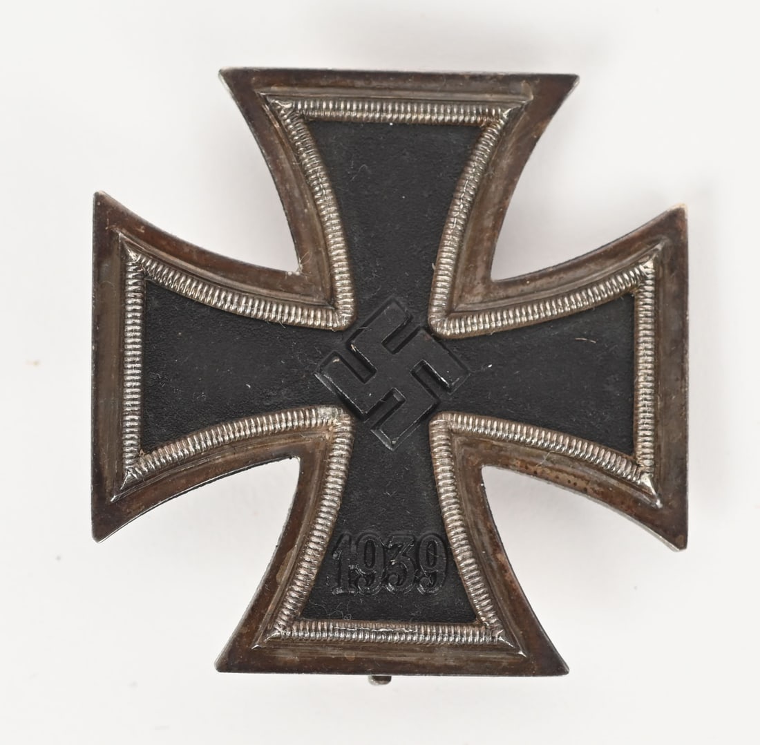 WWII NAZI GERMAN 1ST CLASS IRON CROSS MKD 107 WW2: Die struck alloy construction Patté style cross. Obverse of the award features an embossed central canted swastika and re-institution date, "1939", to bottom arm. Both swastika and date are in nice h