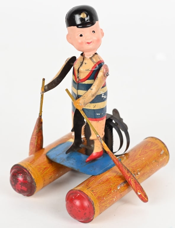 PRE-WAR JAPAN WINDUP MAN WALKING ON WATER: Original celluloid and tin boy standing on logs with paddles that make him move along. Very unusual toy. All original. Windup works. The head is cracked and possible replaced. 6" Excellent