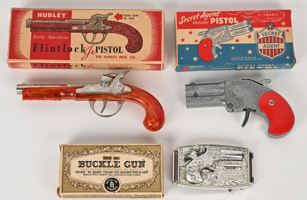 3- CAP GUNS w/ BOXES: includes Hubley Flintlock Pistol, Hamilton Secret Agent Gun, and Mattek Buckle Gun. All original in great shape. All boxed. largest 8" Excellent