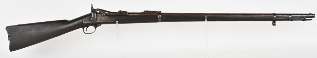US MODEL 1884 TRAPDOOR SPRINGFIELD RIFLE: SERIAL NUMBER: 504872. BARREL: 32 5/8". CALIBER: 45-70. It features two barrel bands, nose cap, ramrod bayonet, and Buffington rear sight. Lock is marked "US SPRINGFIELD" with eagle in center. Breech