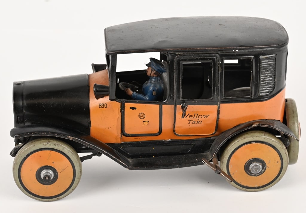 GUNTHERMANN TIN WINDUP YELLOW TAXI: German tin windup Yellow Taxi made by Gunthermann in the 1920's. The toy features a windup motor 2 opening doors, cowl lights, a full bodied driver, and a spare on the back. Windup worked when tested.