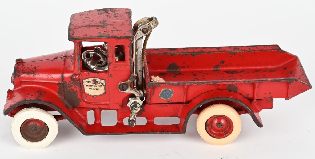 ARCADE CAST IRON INTERNATIONAL RED BABY TRUCK: Arcade International Harvester dump truck with original paint and decals. No cracks or repairs. Three tires are replacements. 10 1/2" Very Good-Excellent