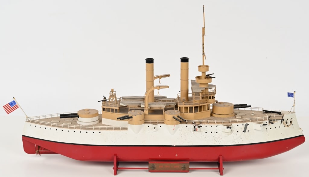 PERCY HANDCRAFTED IOWA TIN BATTLESHIP: Very detailed non mechanical Iowa Battleship with stand Measures 22" long and has moving deck guns. Includes detailed Iowa Battleship supplement to the Philadelphia Inquirer dated July 17, 1898. The s