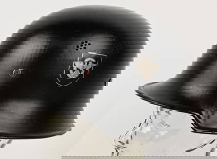 NAZI M34 DOUBLE DECAL FEUERSCHUTZPOLIZEI HELMET: The stamped, sheet steel construction civic M34 helmet retains most of its original black satin finish paint. The left side of the helmet has a silver bordered black based police decal with the second